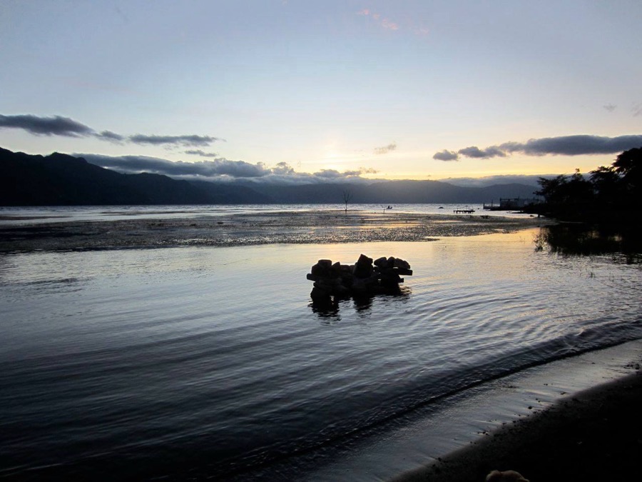 Lake Atitlán at dusk, with mountains across the water